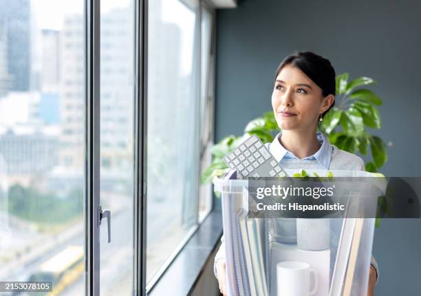 businesswoman quitting her job and carrying a box with her belongings - moving office stock pictures, royalty-free photos & images