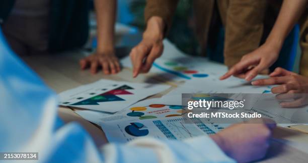 closeup creative business team brainstorming sustainable strategies actively engages in strategizing with graphs and charts during collaborative night meeting. esg sustainable business office. - sustainable development goals stock pictures, royalty-free photos & images