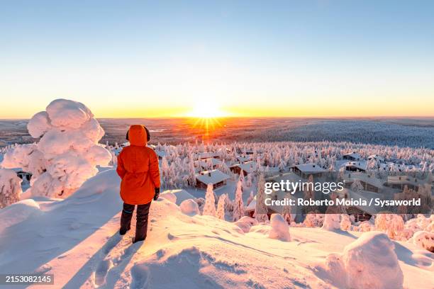hiker admiring sunrise over the snowy icy landscape - finland stock pictures, royalty-free photos & images