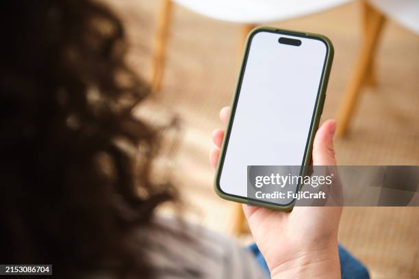 une personne tient un téléphone portable avec une maquette d’écran vide. - téléphone photos et images de collection