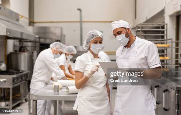 manager talking to a woman working at an industrial bakery - food processing plant stock pictures, royalty-free photos & images