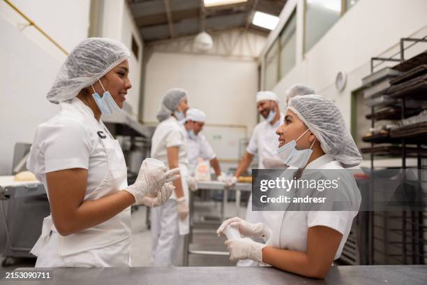 women working at a food factory and drinking coffee while taking a break - coffee manufacturing stock pictures, royalty-free photos & images
