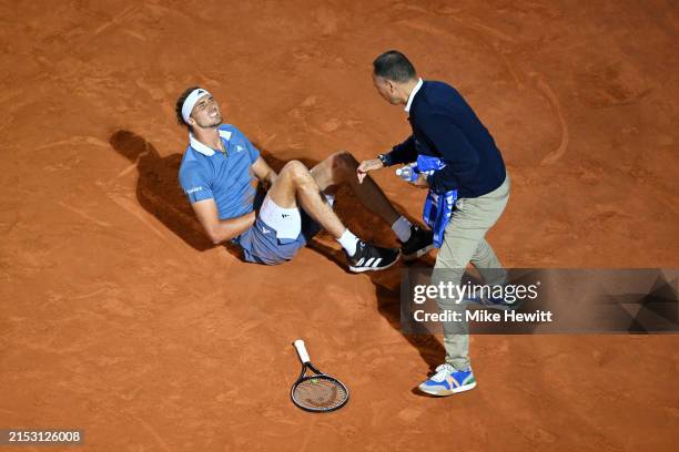 Alexander Zverev of Germany is checked on by Match Umpire Mohamed Lahyani after falling against Taylor Fritz of United States during their Men's...