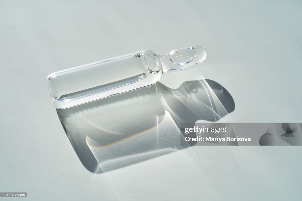 Ampoule with a medical product on a gray-blue background.