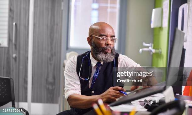 male gp working on a computer - medical record stock pictures, royalty-free photos & images