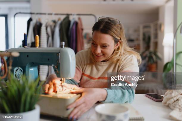 lässig gekleidete frau, die zu hause näht - nähen stock-fotos und bilder