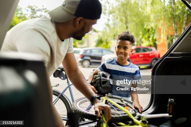 happy boy and his dad going for a bicycle ride - father son on motor cycle stock pictures, royalty-free photos & images