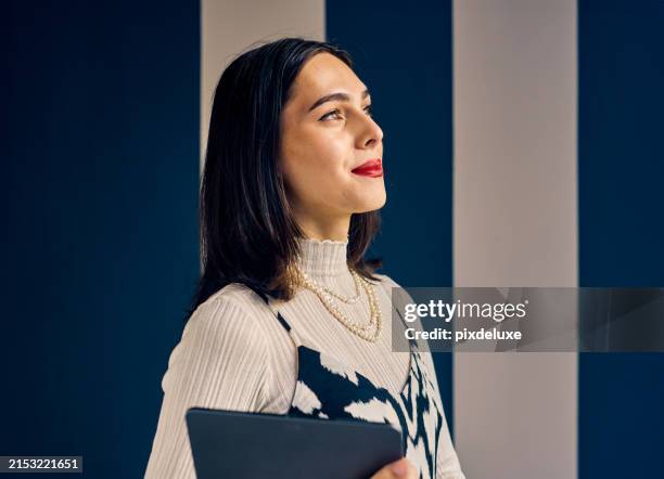 confident transgender woman in an office setting, holding a tablet. empowerment and professional growth in business concept. - vanguardians stock-fotos und bilder
