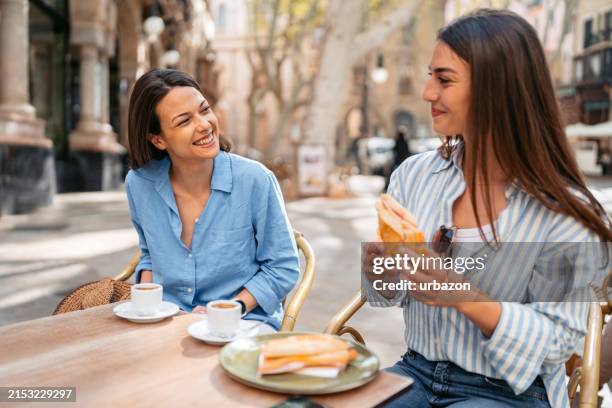 dos amigas comiendo y bebiendo en un café en la acera en palma de mallorca en españa - terraza de cafetería fotografías e imágenes de stock