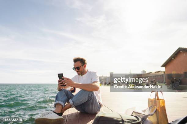 man sitting on the pier - holiday zoom stock pictures, royalty-free photos & images