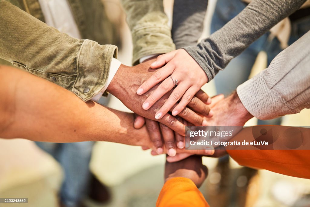 A midsection of businesspeople putting hands together