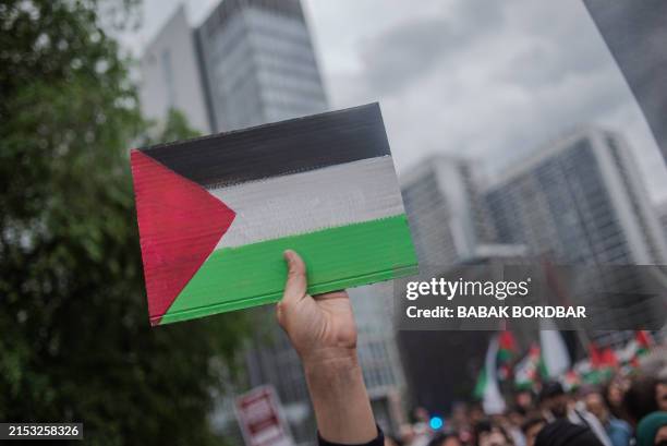 Protester hold a Palestinian flag during a Pro-Palestine demonstration held in Berlin, Germany, on May 18, 2024. Hundreds of people rallied in...