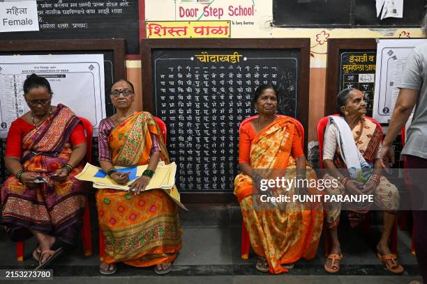 Women queue up to cast their ballots at a polling station during the fifth phase of voting in India's general election, in Mumbai on May 20, 2024....