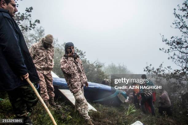 Rescue team members work at the crash site of a helicopter carrying Iranian President Ebrahim Raisi in Varzaghan, in northwestern Iran, on May 20,...