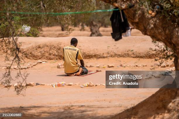African irregular migrants pray on the deserted field as they live under difficult conditions at Amra town in Sfax, Tunisia on May 19, 2024. Every...