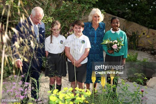 Britain's King Charles III and Britain's Queen Camilla meet with pupils of the Sulivan Primary school as they visit the No Adults Allowed Garden,...