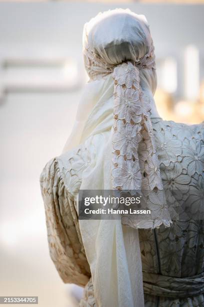 Guest wearing white lace head scarf during Australian Fashion Week Presented By Pandora 2024 at Carriageworks on May 17, 2024 in Sydney, Australia.