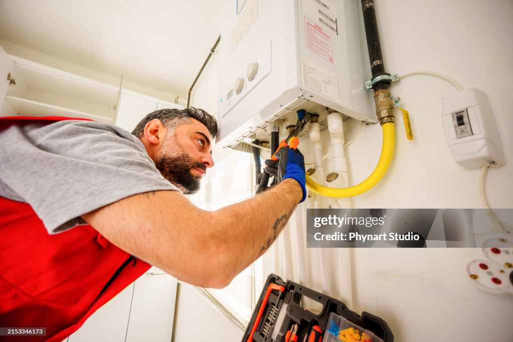 One man repair gas boiler with wrenches, Gas Heating Boiler Service At Home