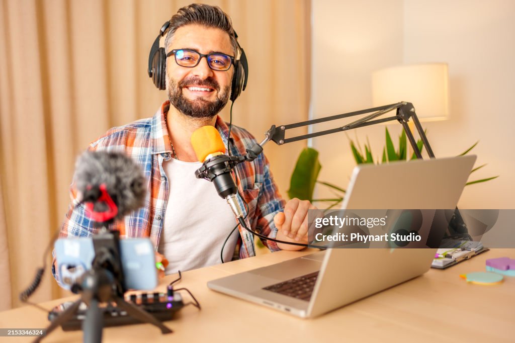 Mature man recording a podcast in a home studio