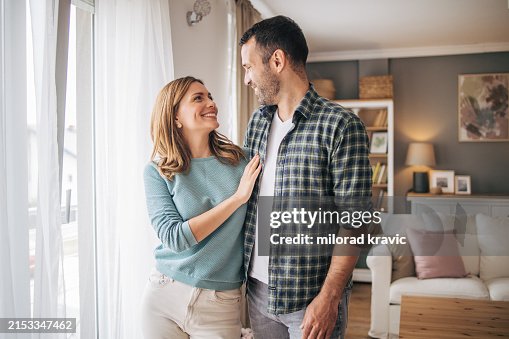 Portrait of a happy young couple smiling while standing together and looking at each other Portrait of a happy young couple smiling while standing together and looking at each other