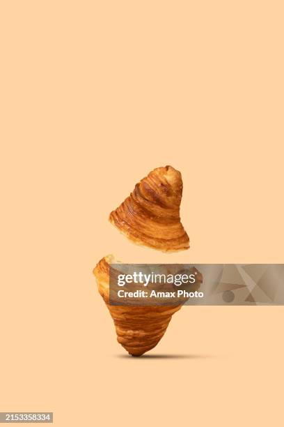 a split croissant levitates against a pastel peach background - peach isolated stock pictures, royalty-free photos & images