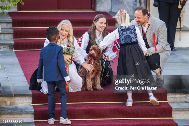 Crown Princess Mette Marit, Princess Ingrid Alexandra and Crown Prince Haakon Magnus get flowers from two school children during the children's...