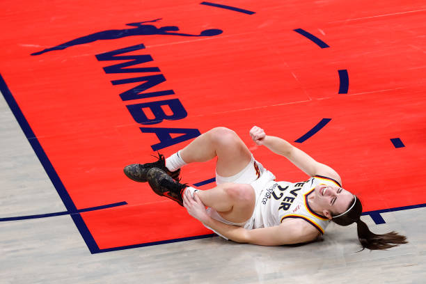Indiana Fever guard Caitlin Clark grimaces in pain as she grabs her ankle in the second quarter of play during the WNBA game between the Connecticut...