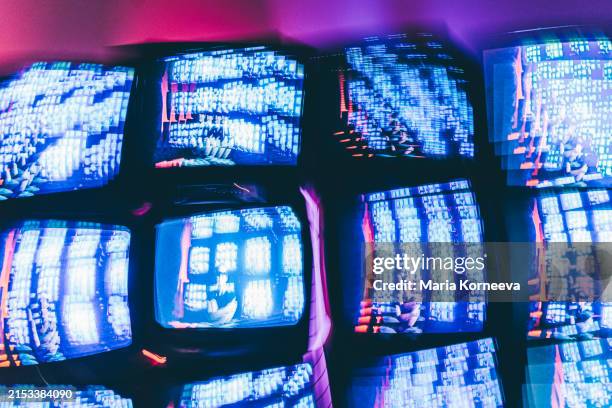 online privacy violations. big brother is behind you. several tvs against a neon wall. - control room stock pictures, royalty-free photos & images