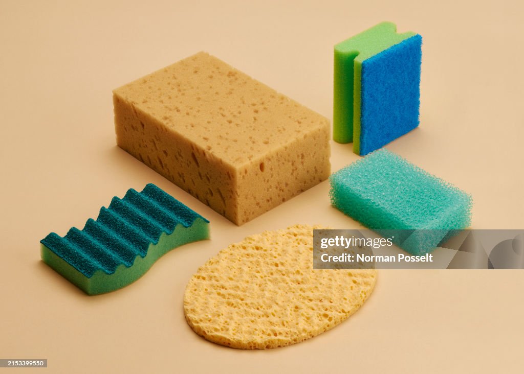 Still life variety of cleaning sponges arranged on beige background