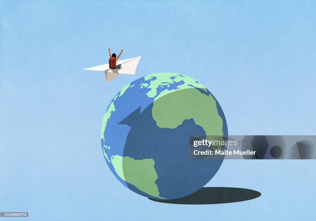 Carefree woman with backpack flying on paper airplane over globe