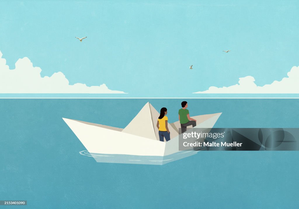 Couple floating in paper boat on ocean