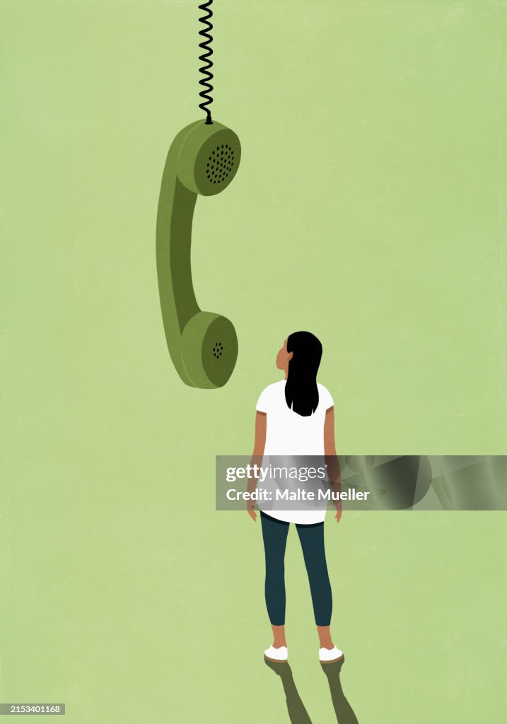 Woman looking at large green telephone receiver