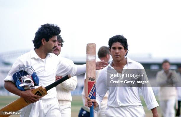 India batsman Sachin Tendulkar raises his bat as he is congratulated by Manoj Prabhakar after finishing 119* at the end of day five of the 2nd Test...