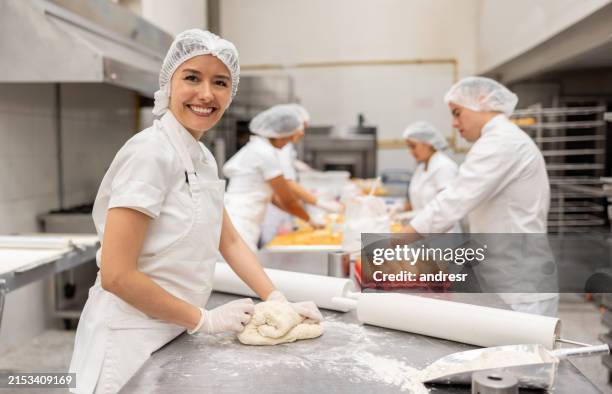 panadero feliz amasando la masa en una panadería industrial - procesamiento fotografías e imágenes de stock