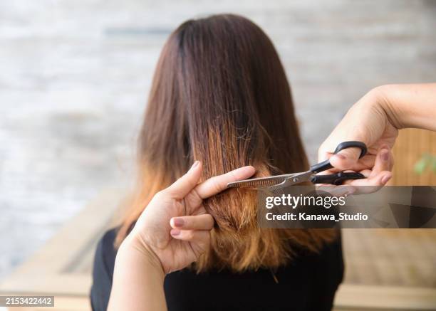 unkenntliche handmessung der länge von geschädigtem haar zum abschneiden - gefärbtes haar stock-fotos und bilder