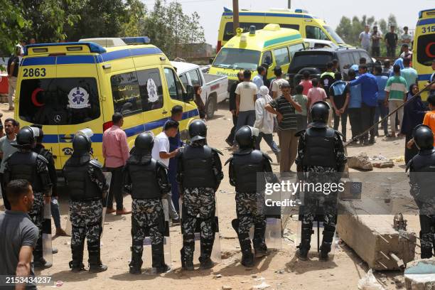 Security forces deploy as relatives wait on the bank of a canal of the Nile River during search and rescue operations for casualties after a minibus...