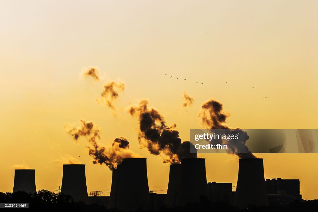 Silhouette of many large cooling towers of a coal fired power plant at sunrise (Jänschwalde, Brandenburg State/ Germany)