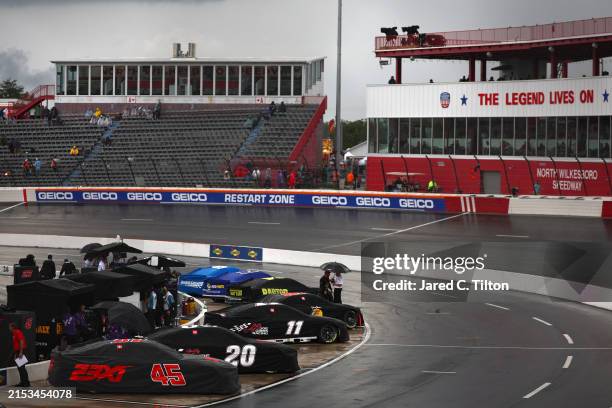 General view of cars covered and parked on the grid during a weather delay in qualifying for the NASCAR Cup Series All-Star Open at North Wilkesboro...