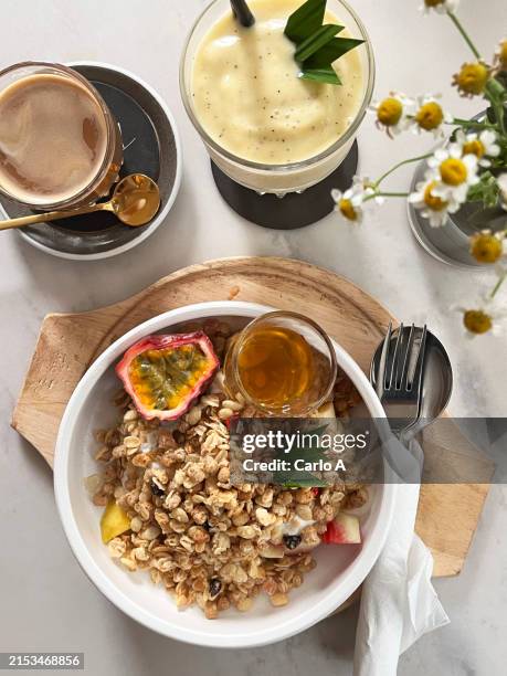 bowl of yogurt with honey, fruit, and granola at cafe - grão integral imagens e fotografias de stock
