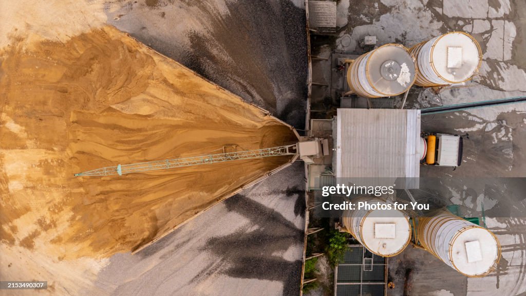 Aerial view/Cement mixing plant where cement is being mixed in cement trucks to the construction site.