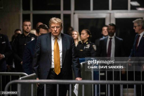 Former US President and Republican presidential candidate Donald Trump arrives to speak to the press at the end of the day's proceedings in his...