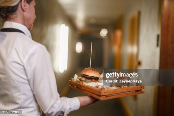 hotel employe serving burgers to the room. - room service stock pictures, royalty-free photos & images