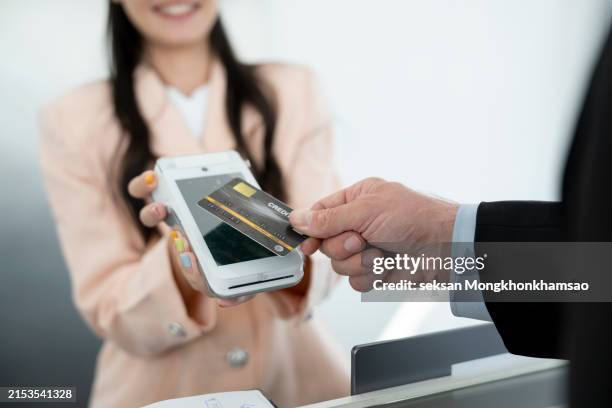 businessman is paying with credit card at the hotel reception - terminal aeroportuale foto e immagini stock