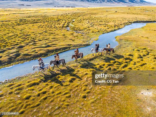 group of kazakh eagle hunters riding horses along river bayan olgii, west mongolia - independent mongolia stock pictures, royalty-free photos & images