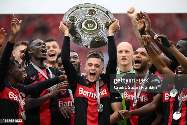 Florian Wirtz of Bayer Leverkusen lifts the Meisterschale of Bundesliga trophy after their team's victory in the Bundesliga match between Bayer 04...