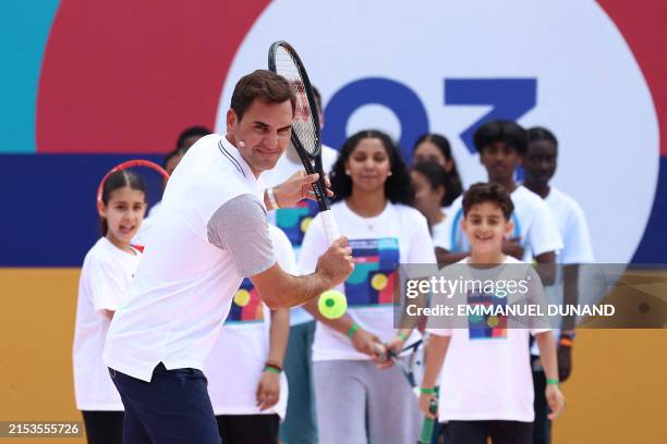 Swiss tennis player Roger Federer plays in front of children as he takes part in the inauguration of a tennis court of the City of 4,000...