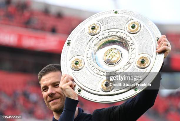 Xabi Alonso, Head Coach of Bayer Leverkusen, celebrates with the Meisterschale of Bundesliga trophy after their team's victory during the Bundesliga...