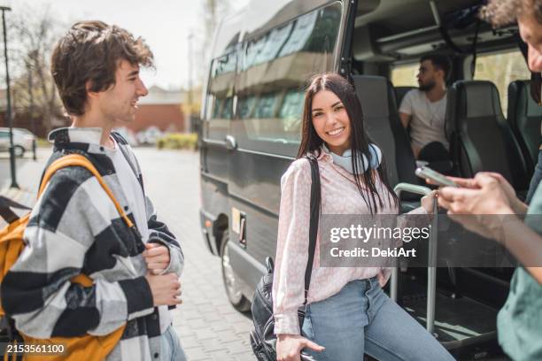 a beautiful woman looks directly into the camera as she boards the minibus - bus tour guide stock pictures, royalty-free photos & images