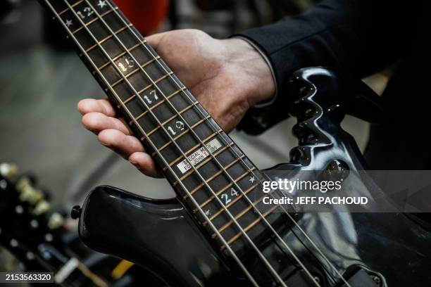 Auctioneer Etienne De Baecque holds the Warwick 4-string Buzzard bass guitar designed by John Entwistle, bassist of famous rock band The Who in a...
