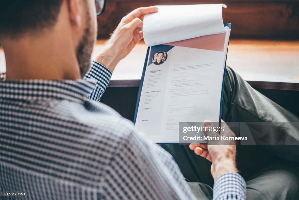 Businessman or HR Manager is reviewing Resume information.